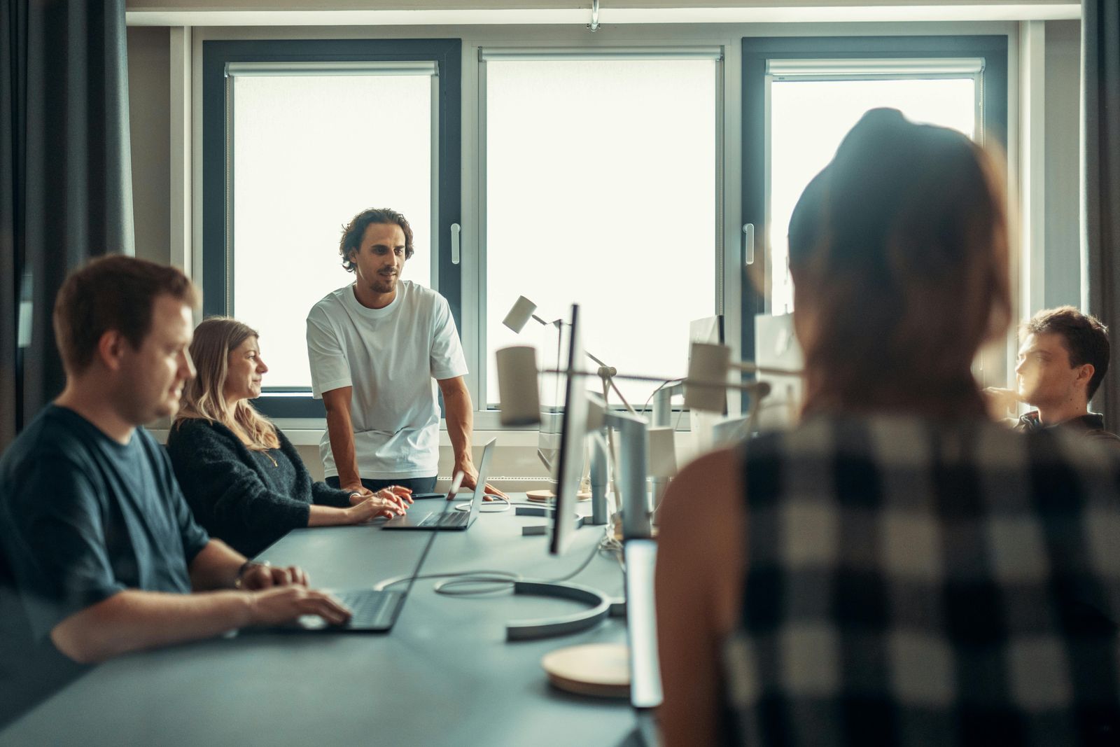 A creative team collaborating around a table in a modern studio