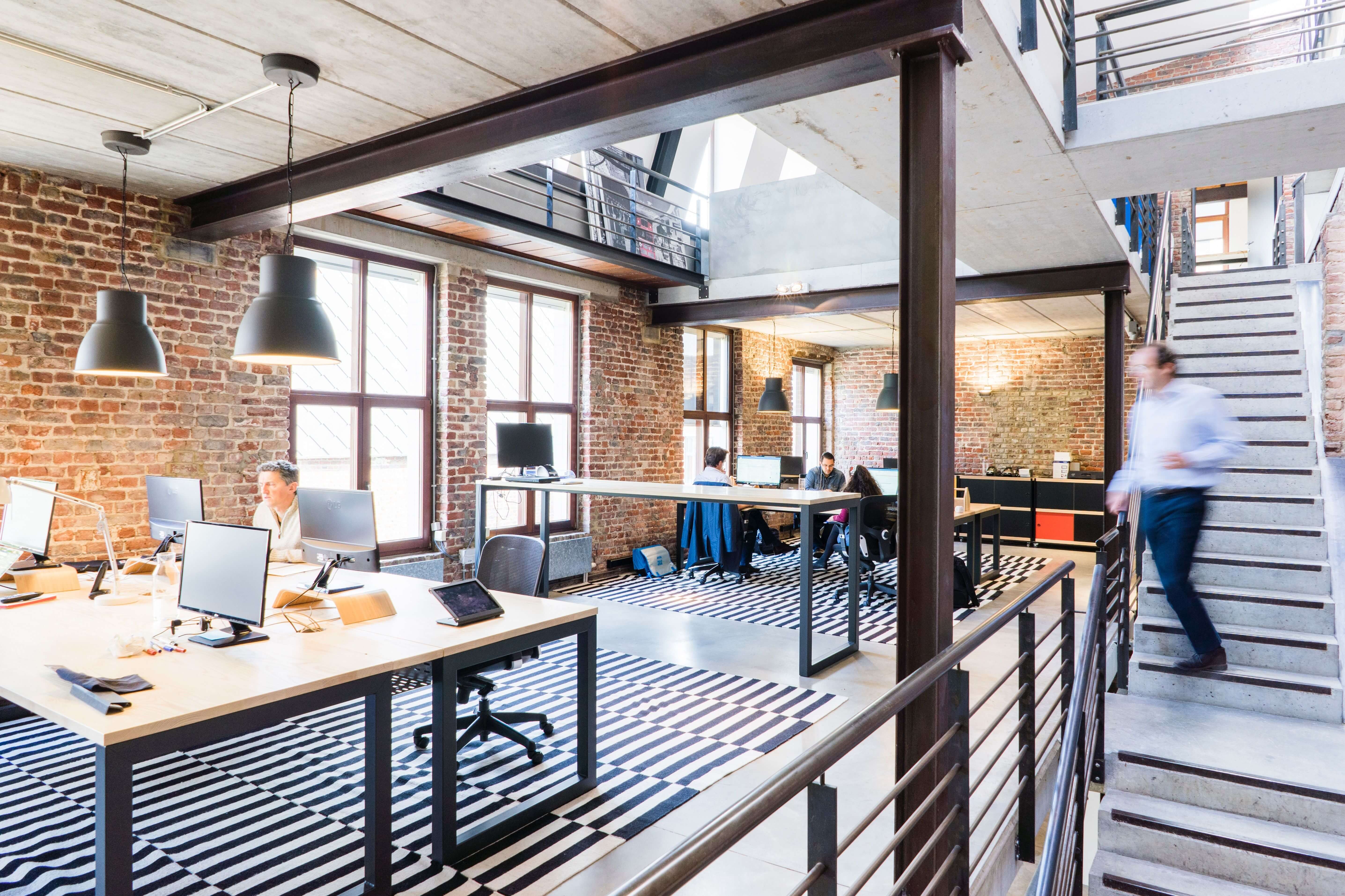 A busy open-plan creative agency office, the kind of team and overhead a fee pays for
