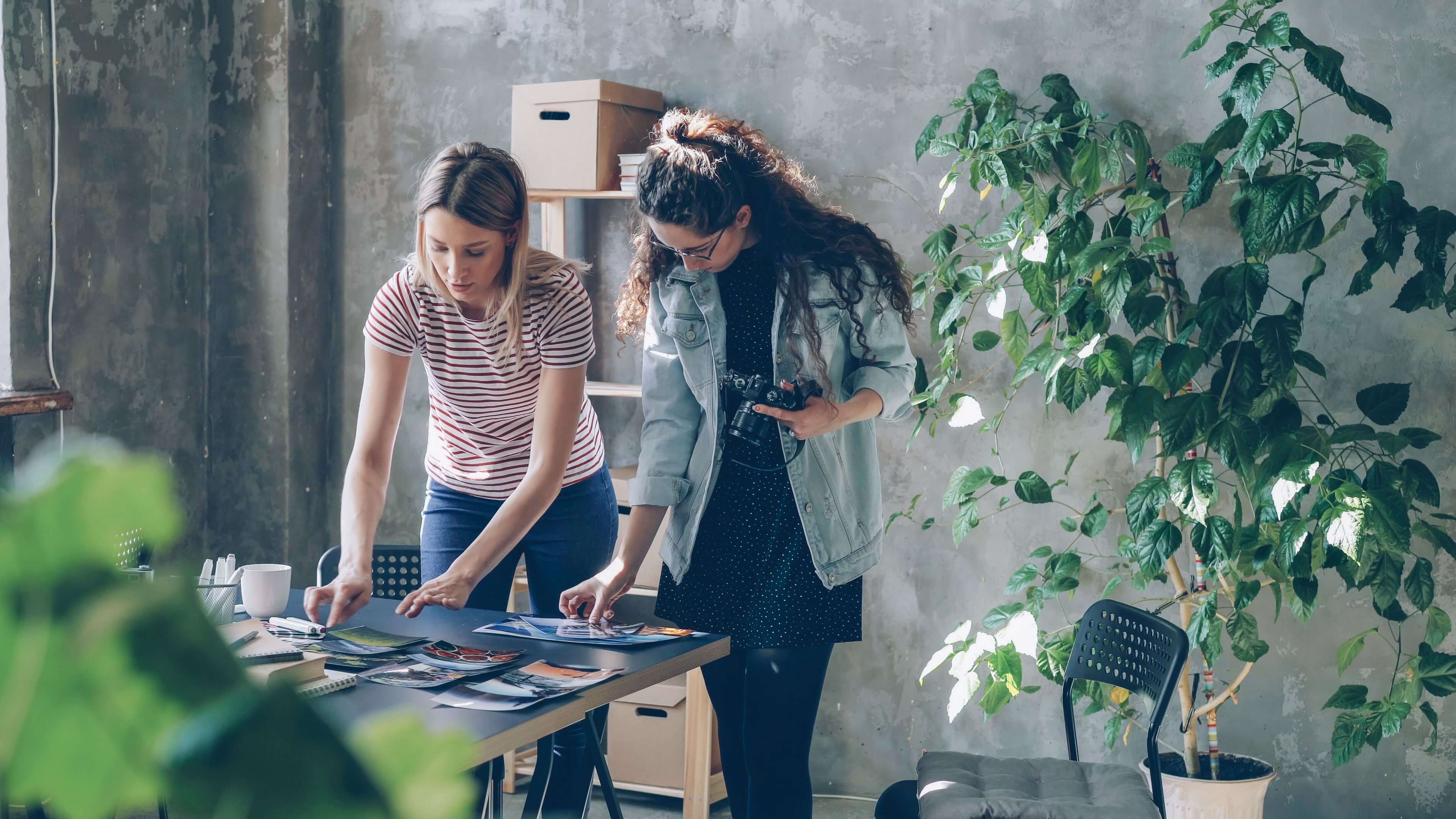Creatives reviewing work together beside a screen, sharing a portfolio for feedback